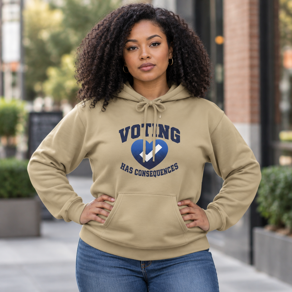 Model wearing a tan Voting Has Consequences hoodie outdoors with hands on hips.
