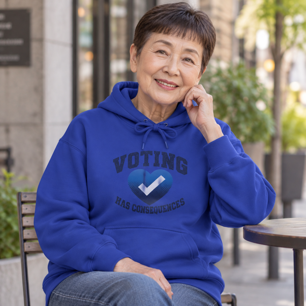 Seated model wearing a deep royal blue Voting Has Consequences hoodie at an outdoor table.